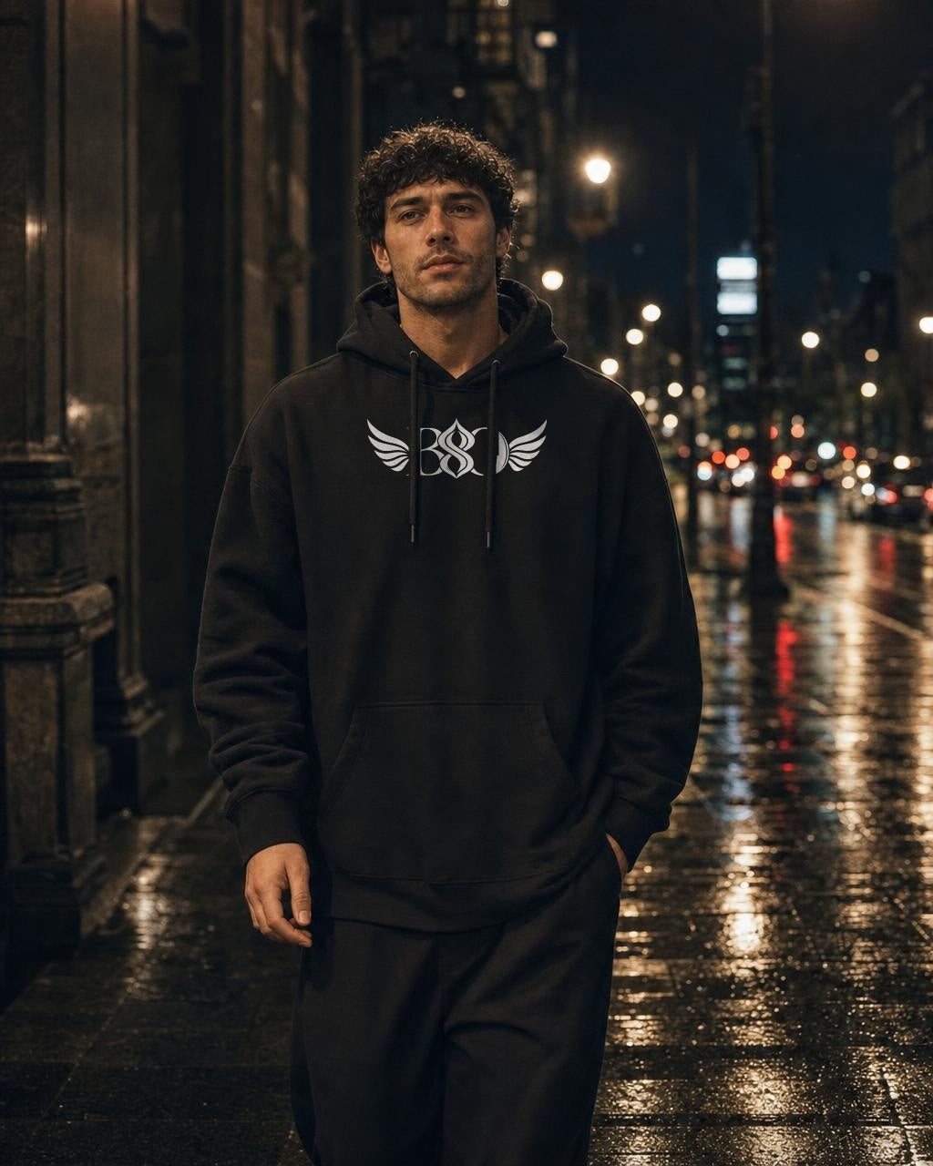 Phoenix Hoodie black — worn, front BSO monogram, city street at night